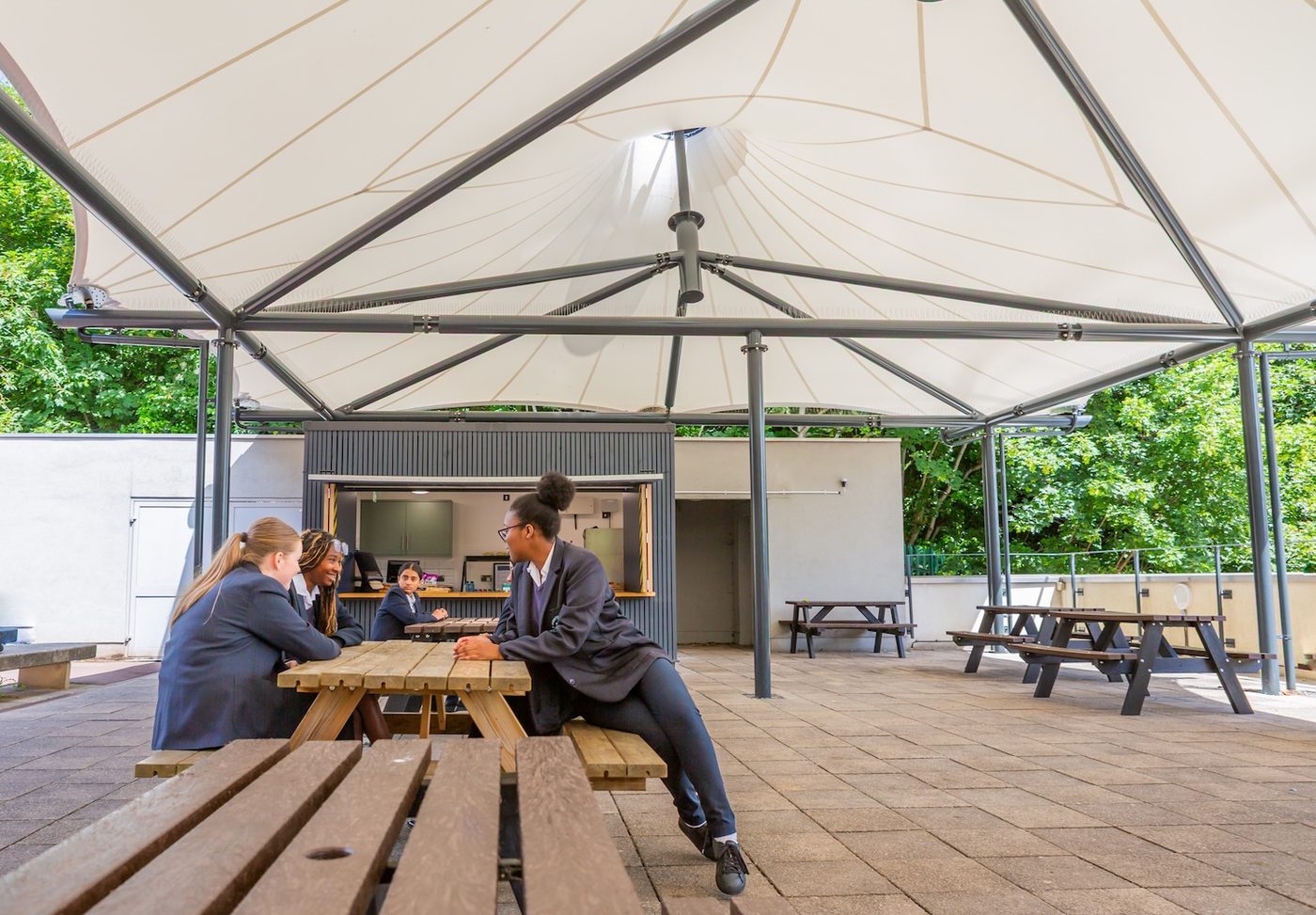 Pupils sheltering under a outdoor school canopy in Bristol