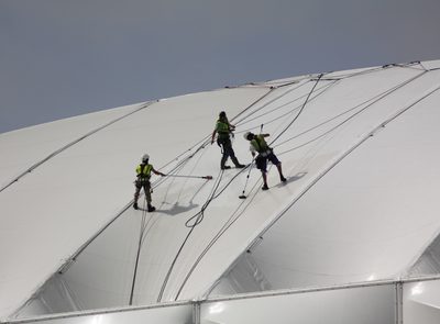 Engineer carrying out canopy maintenance on a tensile fabric structure
